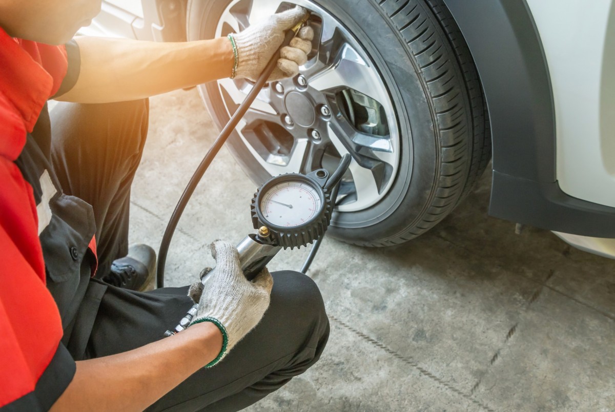 mechanic checking tire pressure on tire