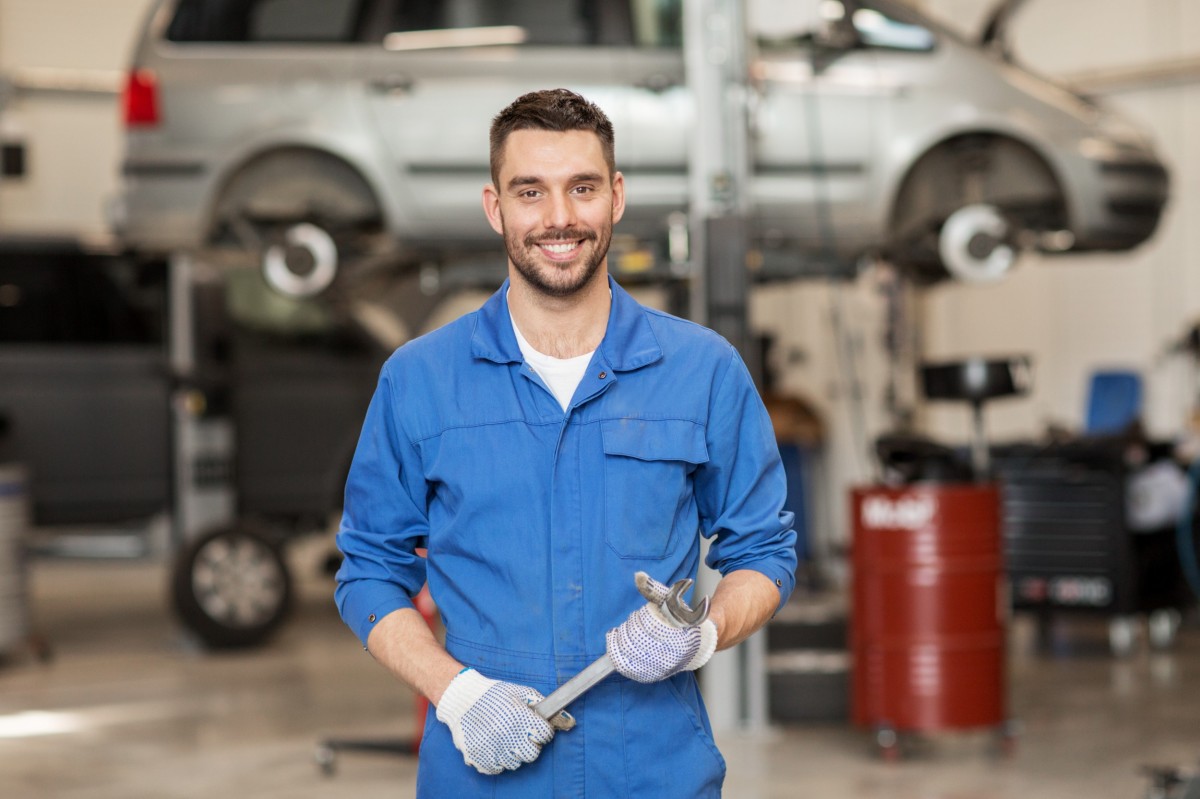 mechanic standing in garage and holding wrench 
