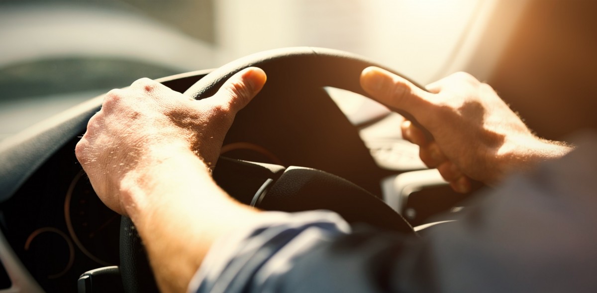 Person driving with hands on the steering wheel