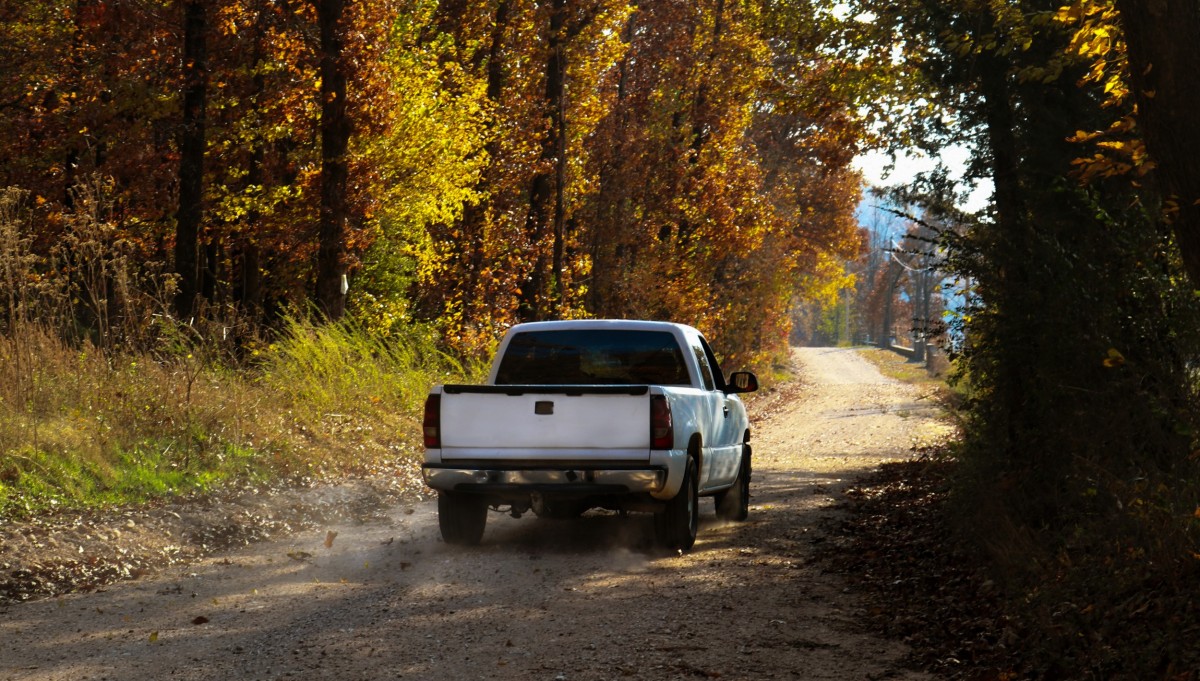 diesel truck driving down road with fall foliage